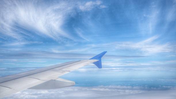 istock wing of airplane and blue sky 960574516