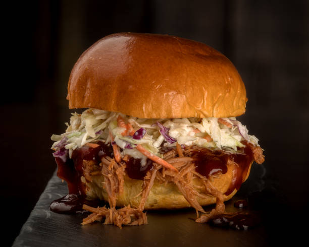 istock Close up of a single pulled pork sandwich with Cole slaw 960575818