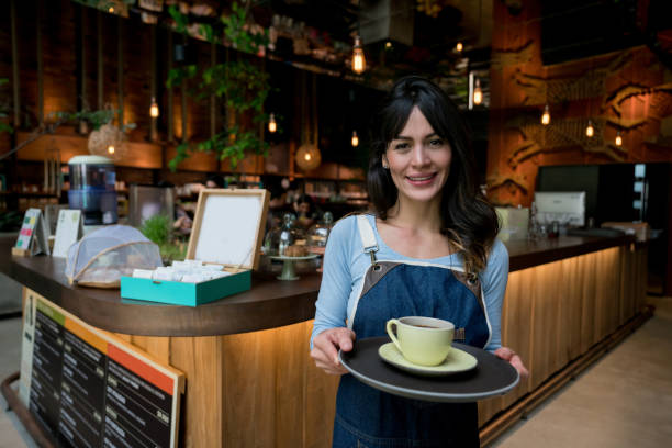 istock Waitress serving a cup of coffee at a cafe 960576306