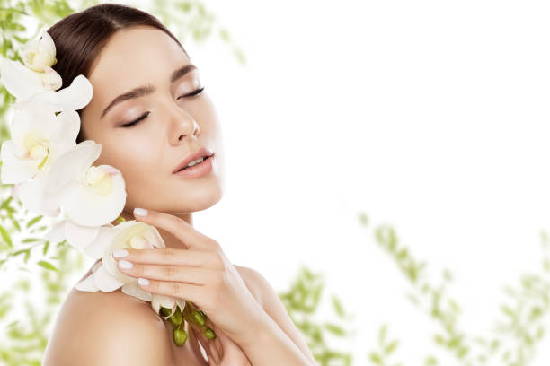 belleza cuidado de la piel y maquillaje de la cara, mujer natural de cuidado de la piel maquillaje, modelo con flor de la orquídea - beauty spa spa treatment health spa orchid fotografías e imágenes de stock