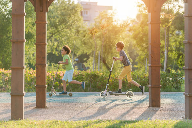 istock Happy Boys with scooter in a park 960578616