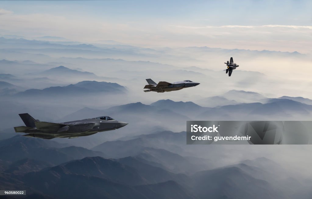 Fighter Jets flying over the misty mountains at dusk F-35 Fighter Jets flying over the misty mountains at dusk Fighter Plane Stock Photo