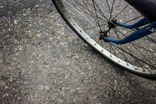old blue bicycle wheel on road asphalt, background and texture