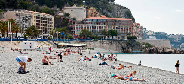 beach with tourists on a hot day in nice, france - swisse imagens e fotografias de stock