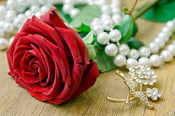istock beautiful red rose with pearl beads on a beige background. 960590530