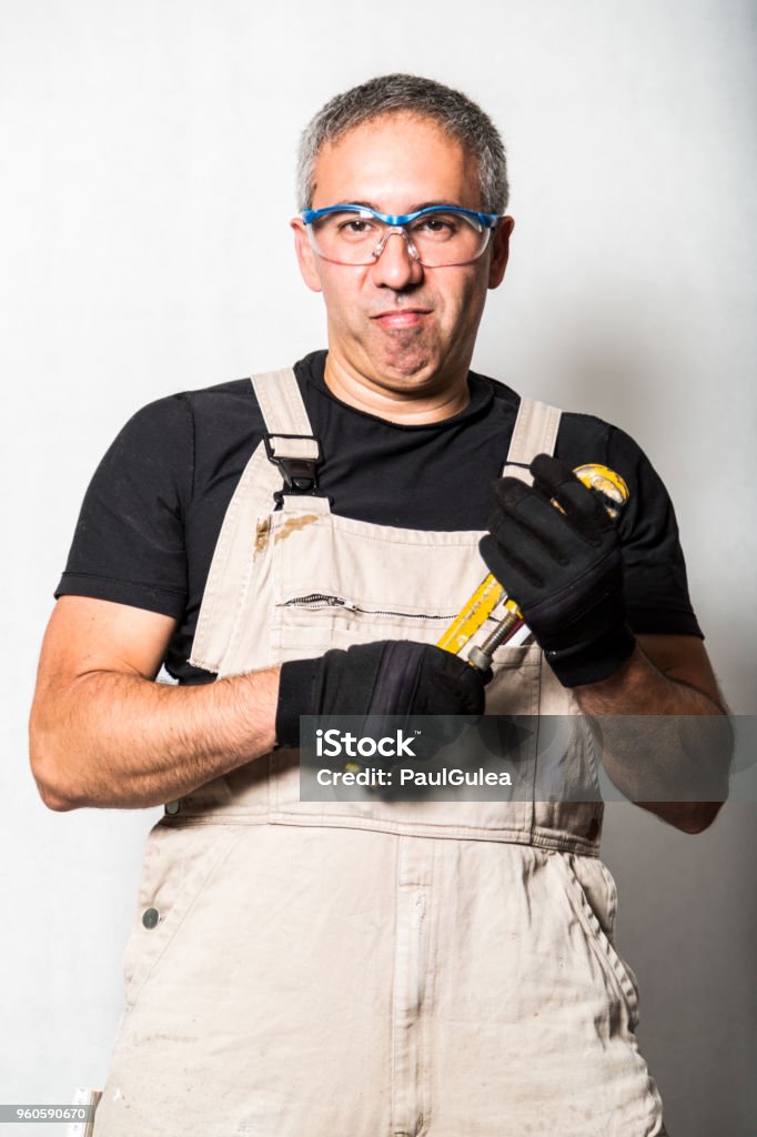 worker specialist plumber, engineer or constructor on white background Male man worker specialist plumber, engineer or constructor in white dirty old shabby working suit, black t-shirt, gloves with yellow wrench and glasses standing on white background with shadow Plumber Stock Photo worker specialist plumber, engineer or constructor on white background Male man worker specialist plumber, engineer or constructor in white dirty old shabby working suit, black t-shirt, gloves with yellow wrench and glasses standing on white background with shadow Plumber Stock Photo