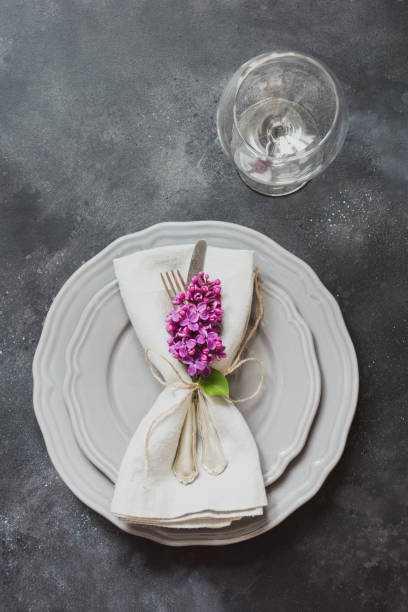 istock Table place setting with pink lilac flowers, silverware on vintage background. View from above. Copy space. 960594616