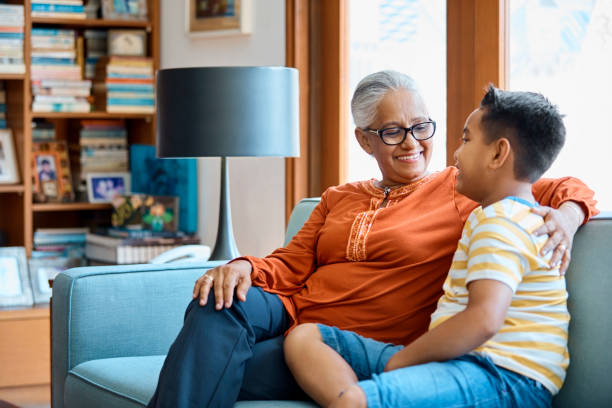 istock Happy grandmother looking at grandson on sofa 960594782