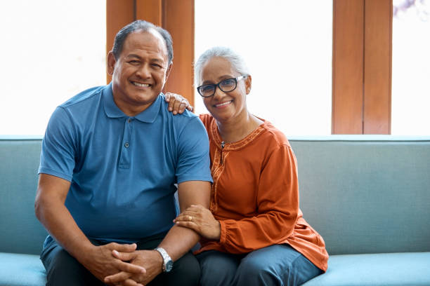 istock Portrait of smiling elderly couple sitting on sofa 960594814