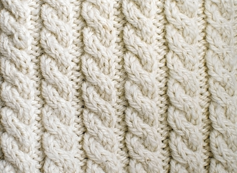 Cream white off-white handmade wool knitwork. Creamy off-white wool knitwork full frame for warming artisan backdrop or background.