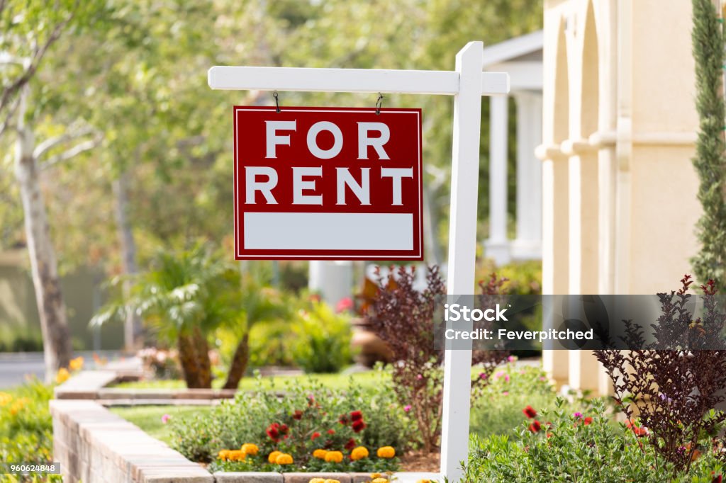 Red For Rent Real Estate Sign in Front House Red For Rent Real Estate Sign in Front House. For Rent Sign Stock Photo