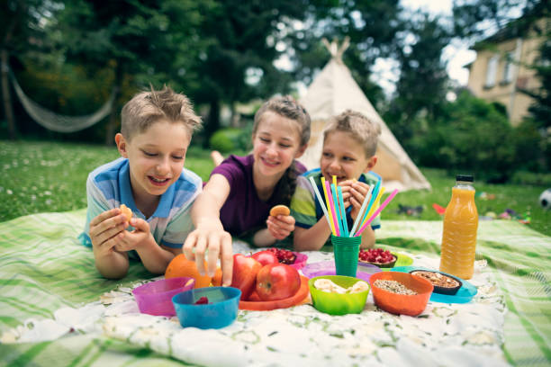 子供の庭でピクニックを楽しんで - healthy lifestyle people eating sister ストックフォトと画像