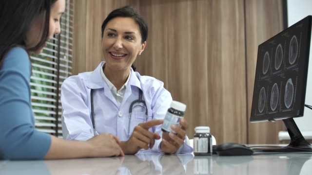 Doctor talking to Asian patient with medicine in Hospital