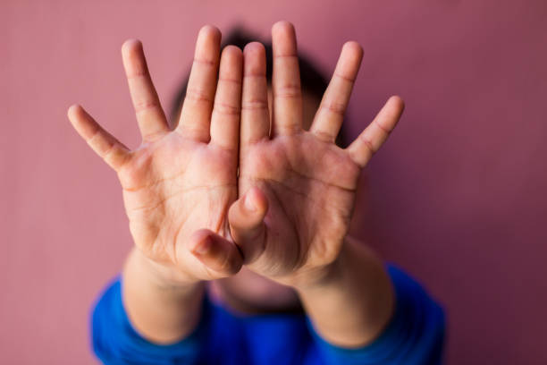 istock Little boy showing stop gesture with his hands,hiding his face. Negative human emotion, sign, gesture, body language. 960638190