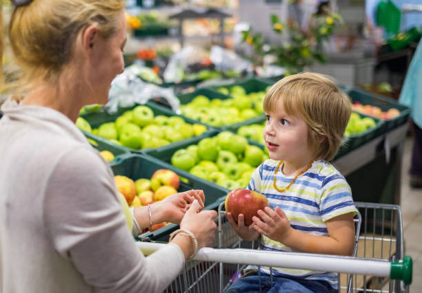 istock Mother and son together in the store picking apple 960638192