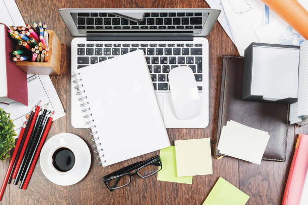 istock Wooden desk top with office items and devices 960638336