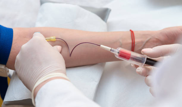 mains de médecin coller l’aiguille dans la veine de femelle pour les prélèvements sanguins - blood sample photos et images de collection