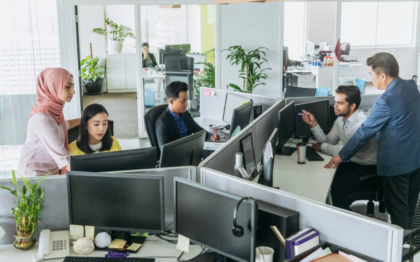 oficina ocupada con los hombres y las mujeres que trabajan en el escritorio - cubicle using computer computer office fotografías e imágenes de stock