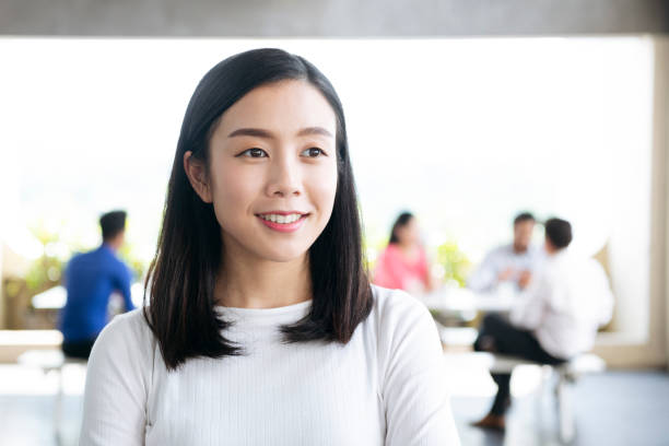 Cheerful young Asian woman looking away and smiling