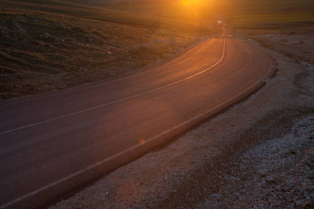 estrada de país único lane em sunset - single lane road road sunset rural scene - fotografias e filmes do acervo