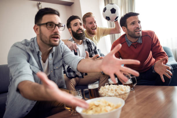 istock Friends watching football game at home 960651908