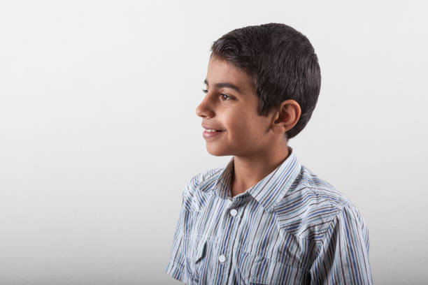 Side view of little boy. He is looking toward left side of horizontal frame. Shot with a full frame DSLR camera.