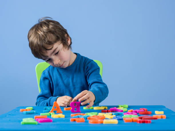 istock Portrait Of Little Boy Playing With Multi Colored Plastic Letters 960659666
