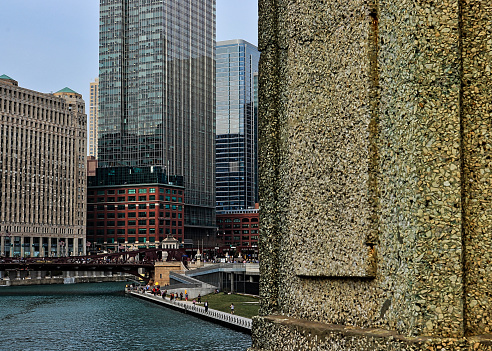Close up view of concrete wall in foreground of Chicago River.