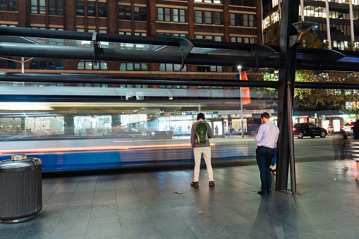 Sydney, Australia - April 17, 2018: People waiting at the bus stop at night.