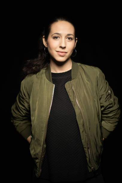istock Woman with hands behind back over black background 960692810