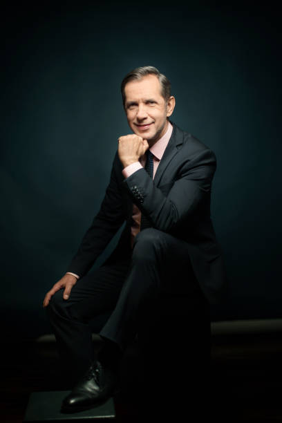 istock Businessman in suit smiling on colored background 960694900