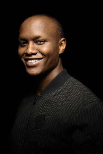 istock Portrait of young man smiling on black background 960694988