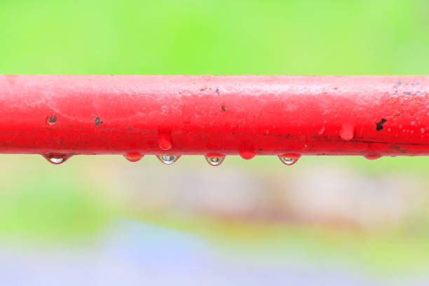 water drops on old metallic steel pipe red background with copy space add text