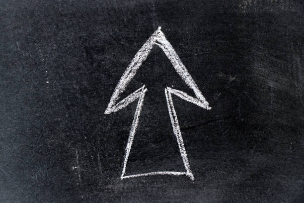 istock White chalk drawing in arrow shape on black board background 960700148
