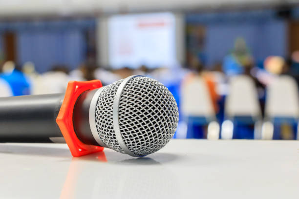 istock Close up microphone wireless old on the table in the conference and Background blur interior seminar meeting room 960701614