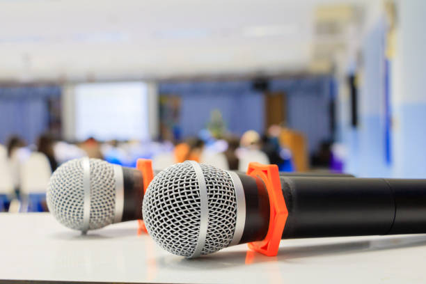 istock Close up microphone wireless old on the table in the conference and Background blur interior seminar meeting room 960702406