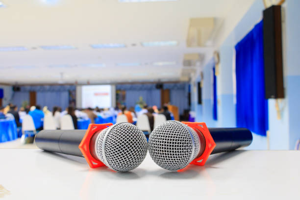 istock Close up microphone wireless old on the table in the conference and Background blur interior seminar meeting room 960702412