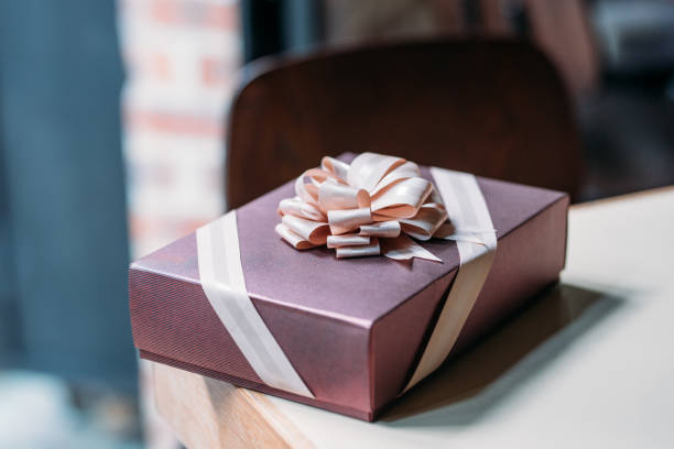 istock Gift box with golden ribbon on wooden table 960703498