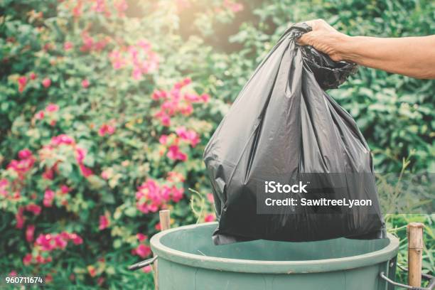 Old Hand Holding Plastic Bag In To Trash Stock Photo - Download Image Now - Garbage, Garbage Bag, Throwing