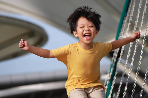 遊び心のある少年が公園で喜びのためにジャンプ - child outdoors action freedom ストックフォトと画像