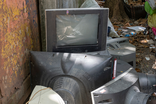 old TV garbage, rubbish, electronic junk, Recycling Electronics, Pile of broken television stacked for disposal. logos, brand names have removed. Great for background, recycle and environmental theme.