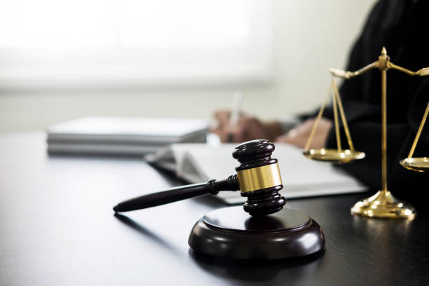 istock Gavel And Weight Scale At Desk With Judge Working In Background 960740384
