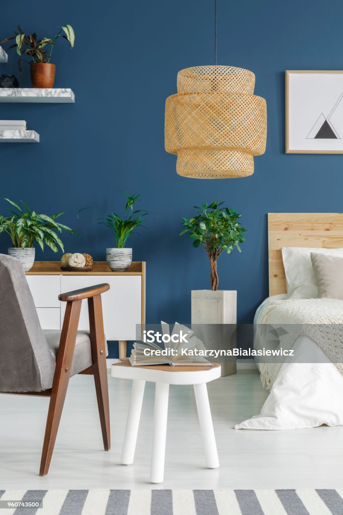 Fresh potted plants Fresh potted plants in blue bedroom interior with big wicker lamp, white cupboard and open book on end table Blue Stock Photo