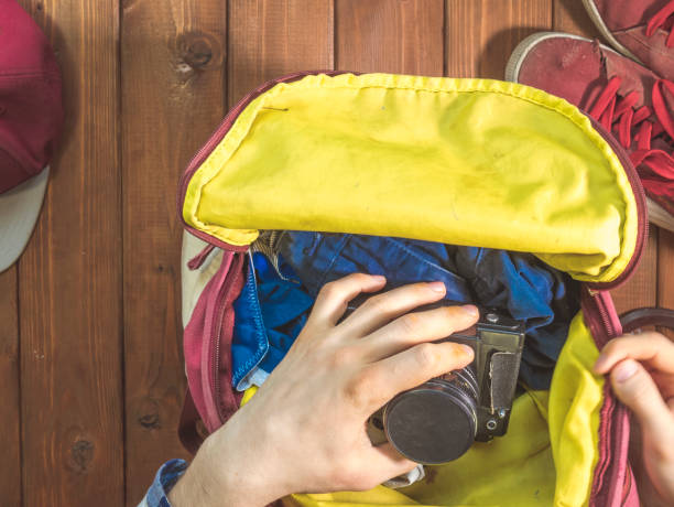 istock travel concept with vintage camera in the hands and backpack on a wooden surface 960743742