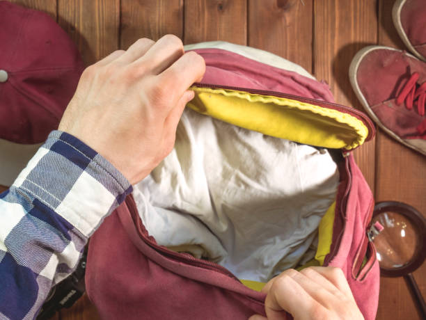 istock hand packing clothes in the backpack for travel with accessories concept 960743938