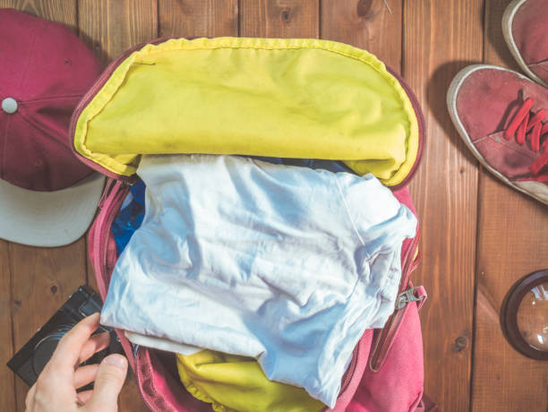istock hand packing clothes in the backpack for travel with accessories concept 960743994