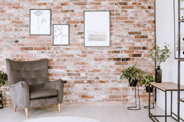 Armchair and plants Grey armchair, plants and posters on the red brick wall white shabby chic desk stock pictures, royalty-free photos & images