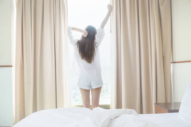 istock Woman stretching in bed after waking up, back view 960752620