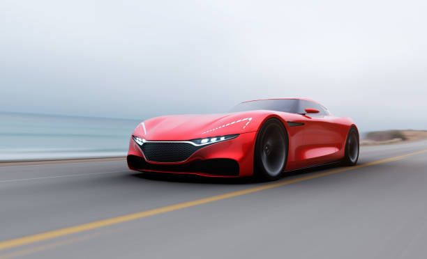 istock red car driving on a road by sea 960754318