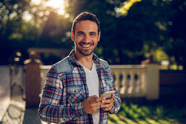 istock Young man text messaging on smart phone outdoors 960767452